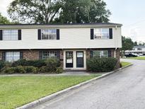 Charming two-story townhouse with brick and siding, complemented by lush green landscaping at 1002 Willow Drive # 63, Chapel Hill, NC 27514
