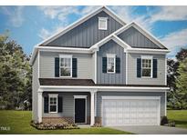 Charming two-story home featuring a welcoming front porch, attached two-car garage, and blue shutters at 158 Mildred Pl, Broadway, NC 27505