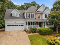 Charming two-story home boasts a well-manicured lawn, two car garage and inviting front porch at 200 Frenchmans Bluff Dr, Cary, NC 27513