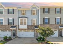 Charming townhome showcasing a brick and siding facade, inviting entrance, and an attached one-car garage at 248 Amber Acorn Ave, Raleigh, NC 27603