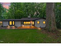 Charming home featuring a brick exterior, front porch, mature trees, and inviting curb appeal at 301 Lord Berkley Rd, Raleigh, NC 27610