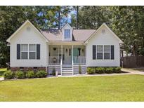 Charming home featuring a well-maintained lawn, classic white siding and a welcoming front porch at 304 Indigo Pl, Garner, NC 27529