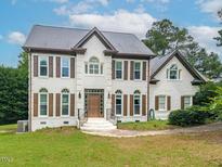 Charming two-story painted brick home with a manicured lawn and detailed trim at 3901 Phlox Rd, Raleigh, NC 27616