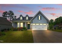 Charming one-story home featuring manicured lawn, dormer windows, and a two-car garage under pink and blue skies at 45 Glen Bend Ct, Spring Lake, NC 28390