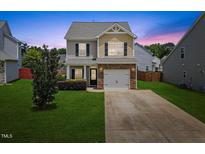 Charming two-story home with a manicured lawn, stone accents, and an attached one car garage at 504 Gumview Cir, Fuquay Varina, NC 27526