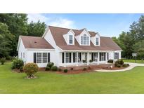 Charming two-story home with a welcoming front porch, well-manicured lawn, and mature landscaping at 541 Mallie Pearce Rd, Zebulon, NC 27597