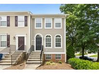 Charming townhome with a black door, arched windows, and well-maintained landscaping at 5545 Crabtree Park Ct, Raleigh, NC 27612