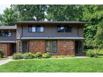 Charming townhome featuring a brick facade and manicured lawn at 606 Oak Tree Dr, Chapel Hill, NC 27517