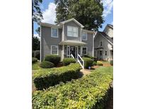 Charming two-story home featuring a well-manicured lawn and beautiful, mature landscaping at 627 New Road, Raleigh, NC 27608