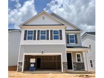 Charming two-story home showcasing a covered entryway, two-car garage, and beautiful architectural details at 709 Emerald Bay Cir # 833, Raleigh, NC 27610