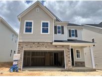 New two-story home with a two-car garage, stone accents, and light-colored siding at 713 Emerald Bay Cir # 834, Raleigh, NC 27529
