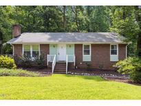 Charming brick home with well-maintained lawn and landscaped garden, offering great curb appeal at 7916 Foxwood Dr, Raleigh, NC 27615