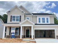 Charming two-story home with stone accents, a welcoming porch, and an attached two-car garage at 820 Emerald Bay Cir # 762, Raleigh, NC 27610