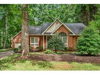 Charming brick home with manicured landscaping and mature trees, creating curb appeal at 101 Turnberry Ln, Cary, NC 27511
