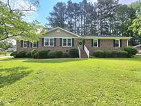 Charming brick home with a well-manicured lawn and mature trees creates a welcoming curb appeal at 112 Saddletree Rd, Oxford, NC 27565