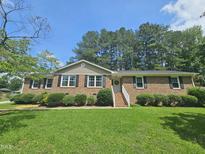 Charming brick home with a well-maintained lawn and landscaping, creating an inviting curb appeal at 112 Saddletree Rd, Oxford, NC 27565