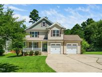 Inviting two-story home featuring a welcoming front porch and a spacious two-car garage at 11612 Leesville Rd, Raleigh, NC 27613