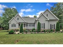 Charming two-story home featuring manicured landscaping, gray siding, black shutters, and a welcoming front porch at 152 Abundant Ave, Angier, NC 27501