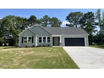 Charming single-story home featuring a well-manicured lawn and a convenient two-car garage at 168 Oakfield Trace Dr, Four Oaks, NC 27524