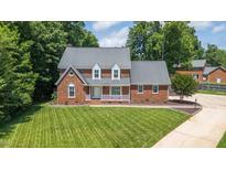 Stunning brick home featuring a meticulously manicured lawn and mature trees in a desirable neighborhood at 213 Brompton Ct, Burlington, NC 27215