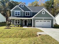 Charming two-story home featuring a spacious two-car garage and a well-manicured lawn at 325 Olde Liberty Dr, Youngsville, NC 27596