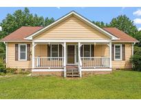 Charming single-story home with a cozy front porch and manicured lawn at 34 Scotts Creek Run, Angier, NC 27501