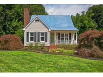 Charming single-Gathering home with a blue roof, brick chimney and a landscaped front yard at 4067 Williams Mill Rd, Burlington, NC 27215