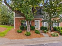 Charming townhome with brick and gray siding, complemented by lush landscaping and a welcoming entrance at 4406 Still Pines Dr, Raleigh, NC 27613