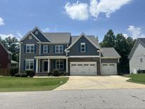 Charming two-story home with a three car garage and a beautifully landscaped front yard at 7008 Rex, Holly Springs, NC 27540