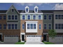 Charming townhome exterior featuring brick facade, white trim, and a two car garage at 952 Westerland Way # 142, Durham, NC 27703