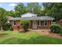 Charming brick house with well-maintained lawn and mature trees at 110 Starlite Dr, Carrboro, NC 27510