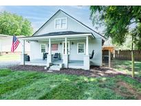 Charming bungalow with gray painted brick, covered porch, and American flag at 1146 W Holt St, Mebane, NC 27302