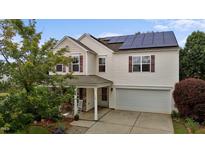Inviting two-story home with solar panels, attached garage, and charming stone-accented front porch at 119 Tadworth Ct, Mebane, NC 27302
