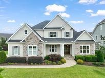 Beautiful home showcasing stone accents, manicured landscaping, and a welcoming front entrance at 121 Hardy Oaks Way, Holly Springs, NC 27540