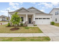 Charming single-Gathering home featuring a welcoming porch, two-car garage, and manicured lawn at 1428 Wrenn Rd, Durham, NC 27703