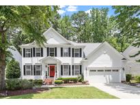 Charming two-story white home with black shutters, a red door and attached two-car garage at 2422 Castleburg Dr, Apex, NC 27523