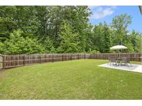 Expansive backyard with lush green grass, privacy fence, and outdoor seating area for entertaining at 267 Dando St, Garner, NC 27529