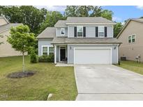 Charming two-story home with a well-manicured lawn and a two-car garage at 267 Dando St, Garner, NC 27529