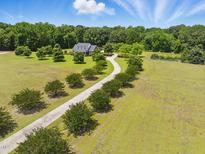 Expansive property featuring a long driveway leading to a beautiful home surrounded by lush greenery and mature trees at 280 Phillips Rd, Selma, NC 27576