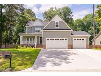 Charming two-story home with a two-car garage, landscaped yard, and lovely curb appeal at 293 Carolina Oaks Ave, Smithfield, NC 27577