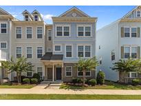 Charming two-story townhome featuring a well-manicured lawn and stylish architectural details at 319 Great Northern Station Sta, Apex, NC 27502