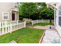 Charming home features a white picket fence and a well-manicured lawn, creating a welcoming entrance at 320 Gilman Ln # 106, Raleigh, NC 27610