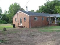 Cozy, one-story brick house featuring a chimney and mature trees at 3514 S Alston Ave, Durham, NC 27713