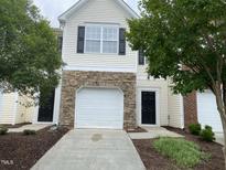 Two-story home featuring a one-car garage with stone accents and a manicured front yard at 545 Writers Way, Morrisville, NC 27560