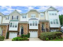 Charming townhome with stone accents, attached garages, and inviting curb appeal at 5916 Longeria Ct, Raleigh, NC 27612