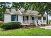 Charming single story home with a covered front porch, mature landscaping, and classic curb appeal at 612 Agin Court Pl, Clayton, NC 27520