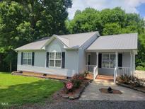 Charming single-story home with a metal roof, landscaped yard, and welcoming front porch at 78 Phil Johnson Rd, Sanford, NC 27330