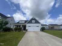 Charming home featuring a two car garage, manicured lawn and flower beds at 83 Mariners Point Way, Garner, NC 27529