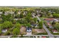 An aerial view of a neighborhood shows a new, two-story home surrounded by lush trees and greenery at 834-836 Day Ave, Burlington, NC 27217