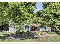 Charming single-story home with mature trees, green shutters, and landscaped front yard at 835 Pearleman Teague Rd, Siler City, NC 27344